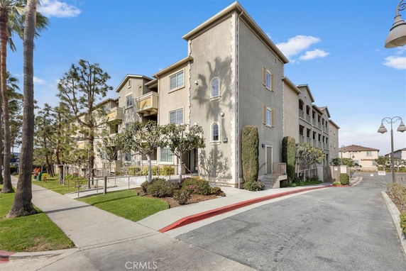 Front view of a multi-story residential building with landscaped surroundings.