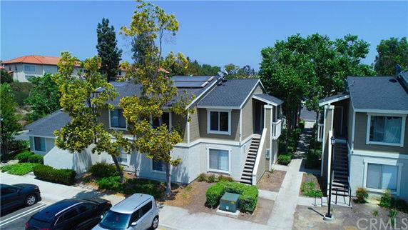 Front view of a two-story residential building with solar panels on the roof.