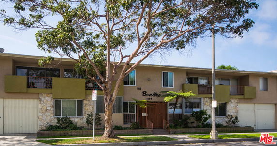 Front view of a two-story apartment building with balconies and a central entrance.