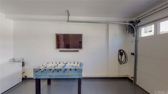 Room with a foosball table and a mounted TV