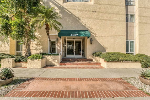 Entrance of a building with a green awning and glass doors.