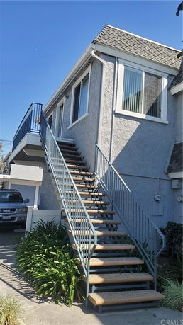 Front view of a house with an external staircase.
