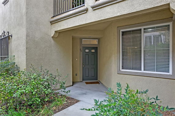 Front view of a building entrance with a green door and a large window.