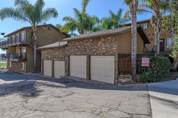 Front view of a house with a stone facade and triple garage doors.