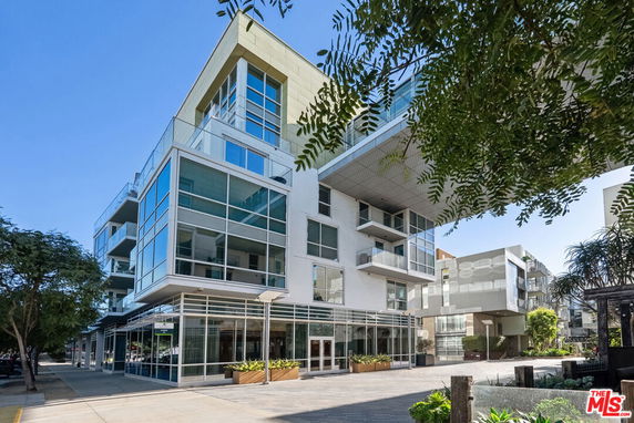 Front view of a modern multi-story building with large glass windows.