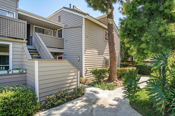 Exterior view of a multi-story residential building with a staircase and balconies.