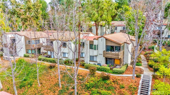 Aerial view of multi-story residential buildings surrounded by trees.