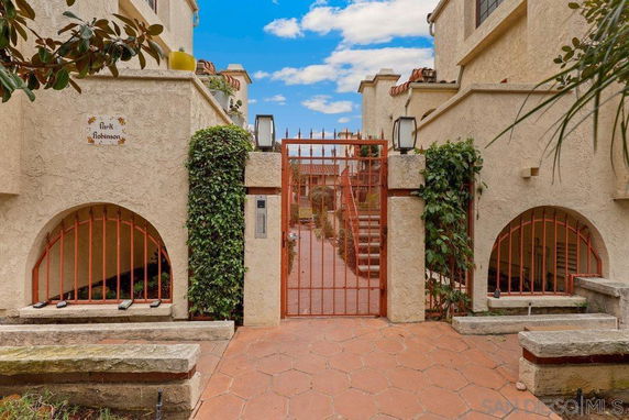 Front view of a multi-story building with a gated entrance and archways.