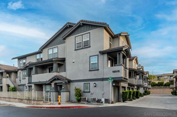 Front view of a multi-story residential building with balconies and multiple units.