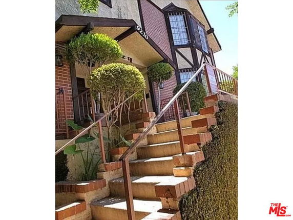 Front view of a house with stairs and brick facade