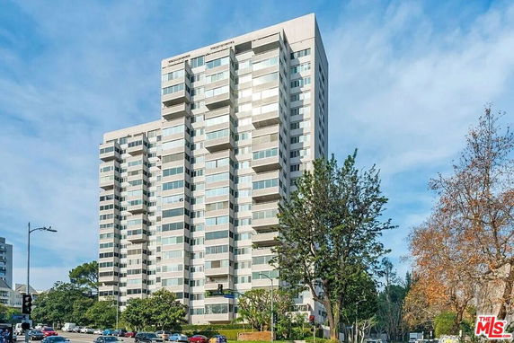 Front view of a multi-story residential building with numerous windows.