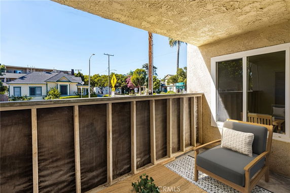 View from a balcony showing adjacent houses and street.