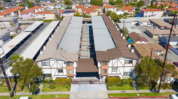 Front view of a multi-story residential building with a gated entrance.