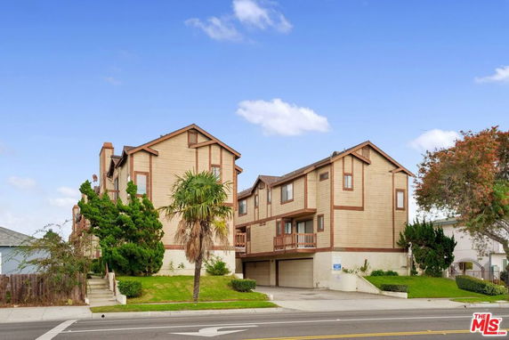 Front view of a multi-story house with wooden exterior and double garage.