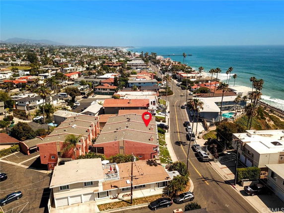 Panoramic view of a coastal residential area with several houses and the ocean in the background.