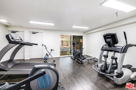 Indoor gym area with exercise equipment including treadmills and stationary bikes.