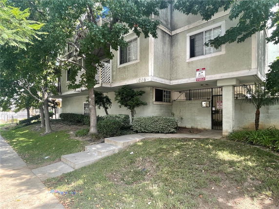 Front view of a multi-story residential building with gated entry.