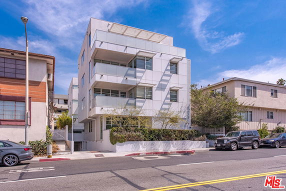 Front view of a modern multi-story building with balconies.