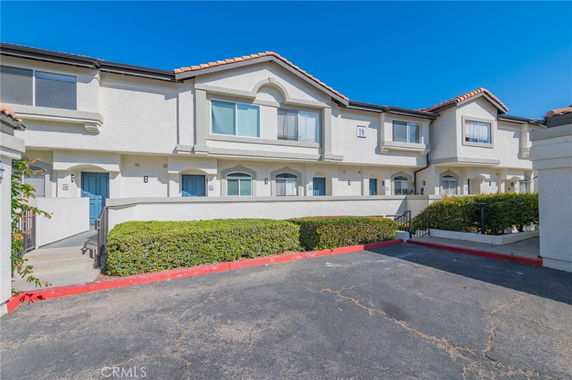 Front view of a multi-story residential building with multiple units and blue doors.