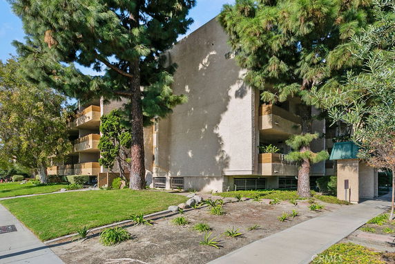 Front view of a multi-story apartment building with balconies.