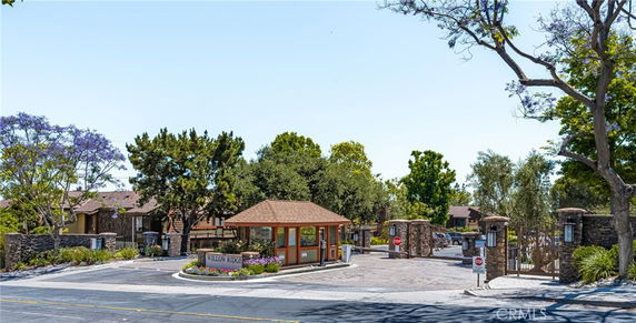 Entrance view of a gated residential community with a security booth.
