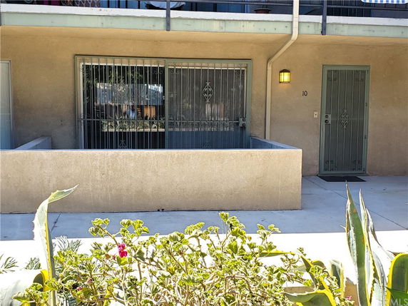 Front view of a residential building with metal doors and window grills.