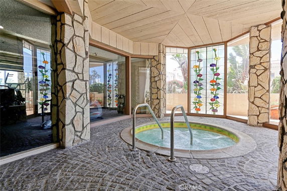 Indoor clubhouse area with a small circular pool surrounded by stone walls and decorative windows.