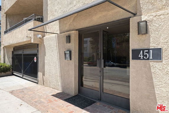 Entrance view of a building with number 451 on the wall.