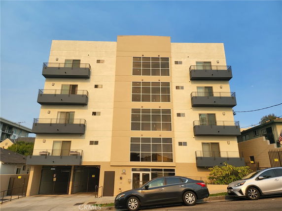 Front view of a multi-story apartment building with balconies.