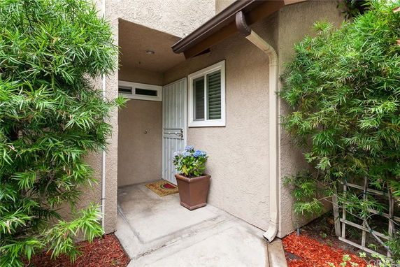Front view of a building entrance with a white door and a small window next to it.