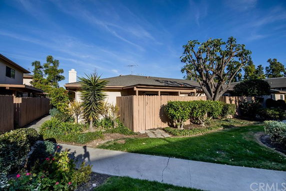 Front view of a single-story house with a fenced yard.