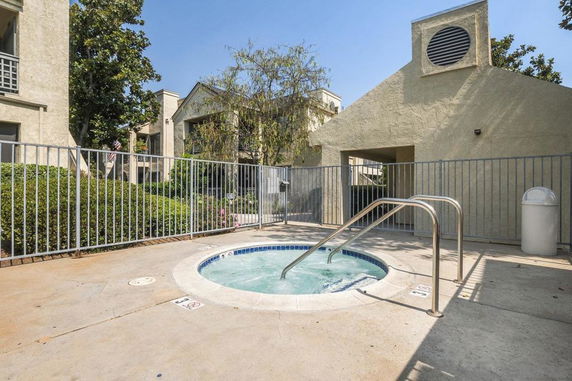 Outdoor area with a small round swimming pool surrounded by a safety fence.