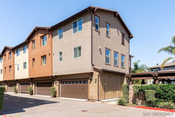 Front view of a multi-story residential building with garages on the ground level.