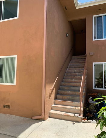 Front view of a building with an exterior staircase leading to the upper level.