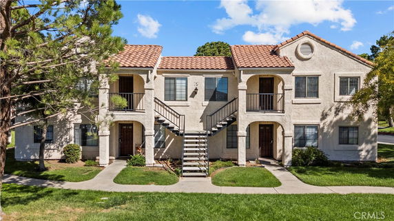 Front view of a two-story residential building with a central staircase and tiled roof.