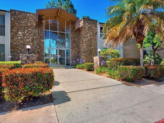 Front view of a building with stone facade and glass entryway.