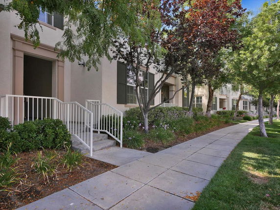 Front view of a house with a pathway and stairs leading to the entrance.