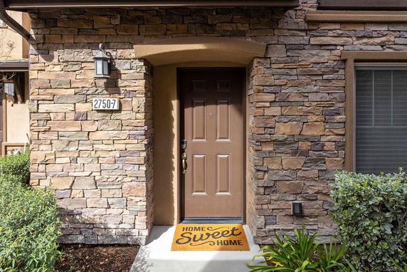 Front view of a house with a stone facade and a brown door.