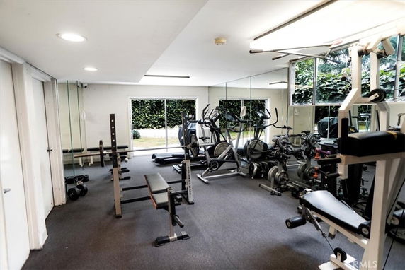 Indoor gym area with various exercise equipment and mirrored walls.