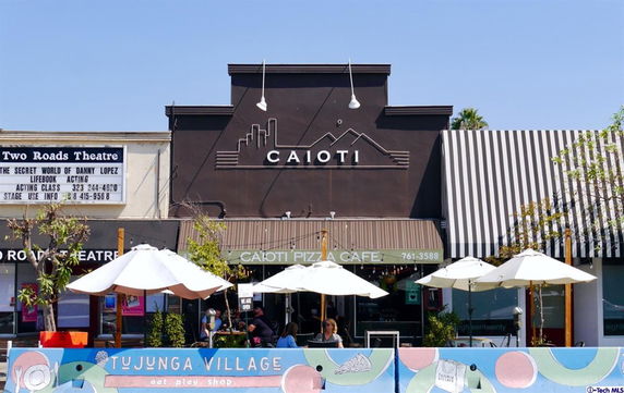 Front view of a café and theater building in a village setting.