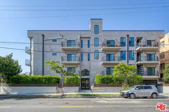 Front view of a multi-story apartment building with balconies.
