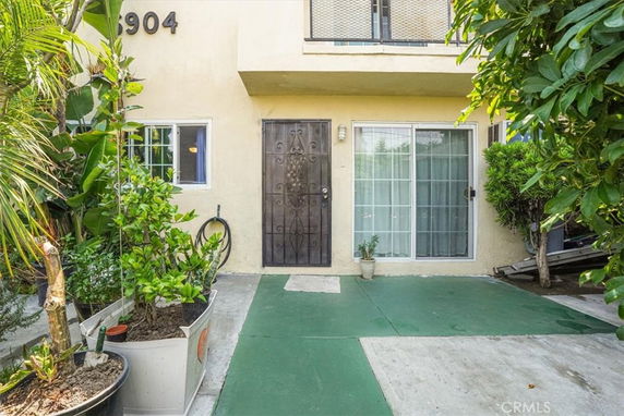 Front view of a house with a decorative metal door and large glass sliding door.