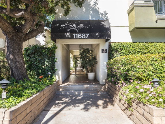 Front entrance view of a building with address number on the awning.