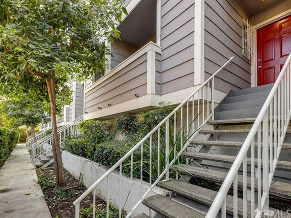 Front view of a building with stairs leading to a red door.