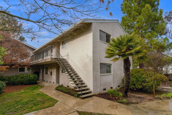 Front view of a two-story residential building with an external staircase.