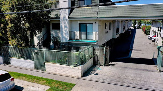 Front view of a multi-story residential building with a gated entrance.