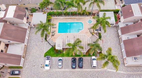 Aerial view of a residential area with a swimming pool and surrounding houses.