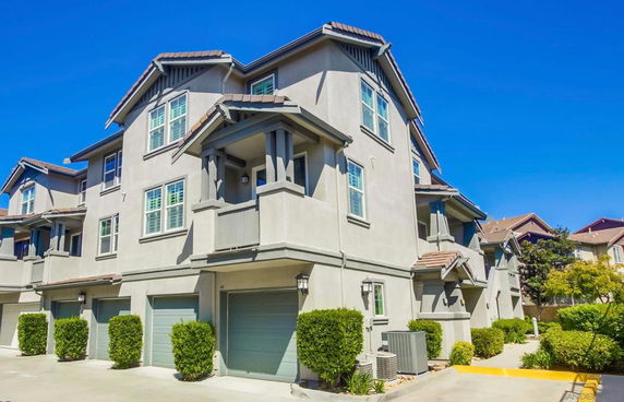 Front view of a three-story townhouse with attached garages.