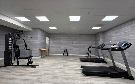 Gym area with exercise equipment including treadmills and weight machines.