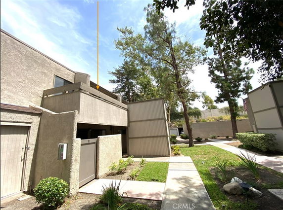 Front view of a two-story building with a balcony and walkway.